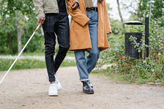 blind man walking with sighted woman